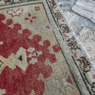 Close-up of the red vintage Turkish area rug showing traditional details, hand-knotted weave, wool and cotton and low pile.