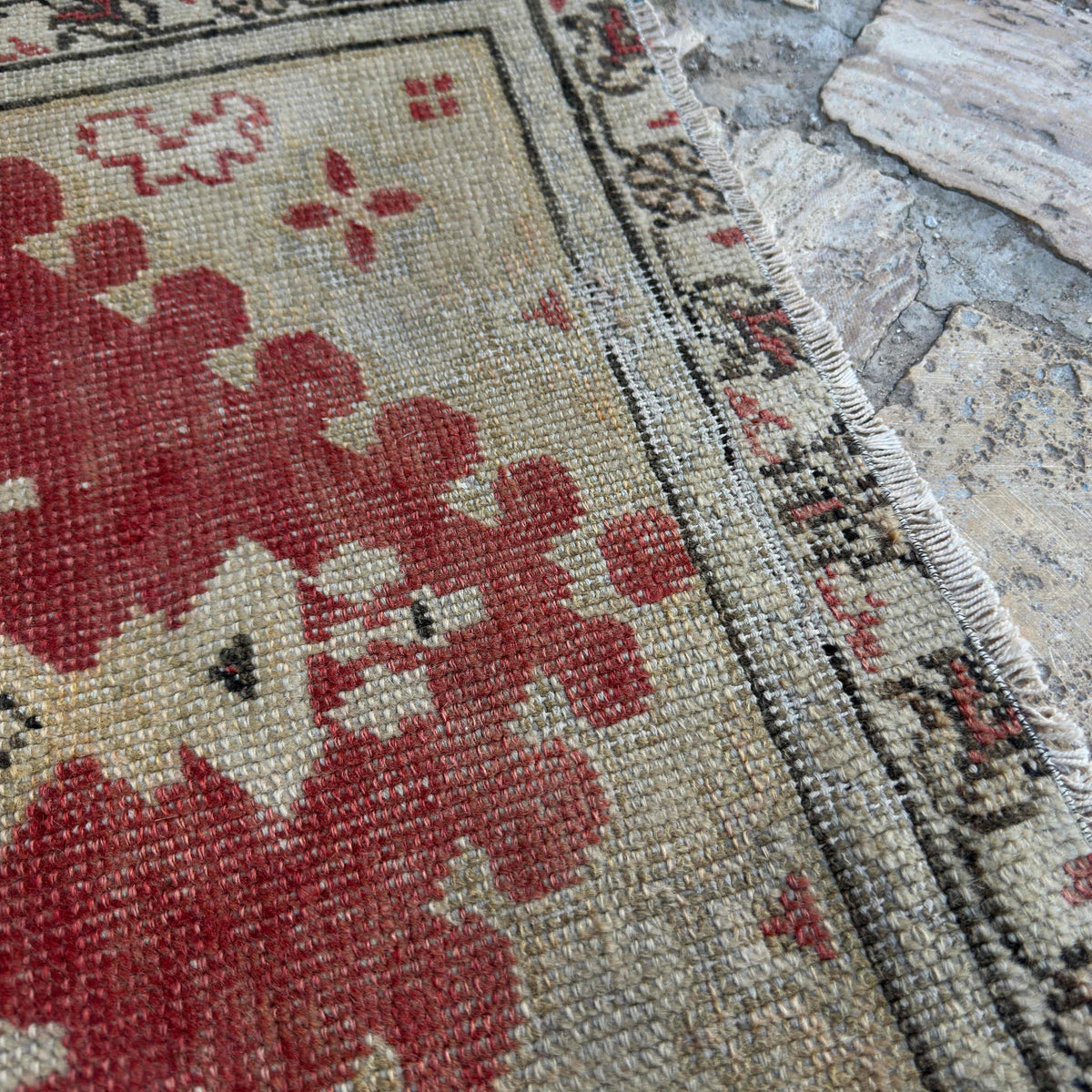 Close-up of the red vintage Turkish area rug showing traditional details, hand-knotted weave, wool and cotton and low pile.