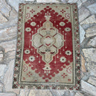 Red 2' x 3' vintage Turkish area rug in wool and cotton, shown on the floor.