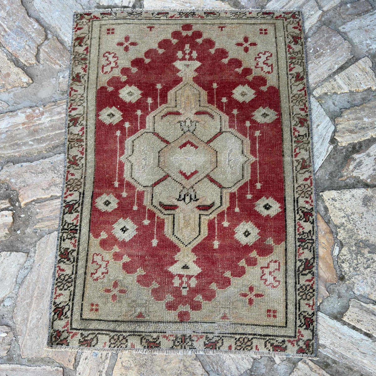 Red 2' x 3' vintage Turkish area rug in wool and cotton, shown on the floor.