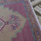 Close-up of the pale pink vintage Turkish area rug showing traditional details, hand-knotted weave, wool and cotton and low pile.