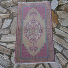 Pale Pink 2' x 4' vintage Turkish area rug in wool and cotton, shown on the floor.