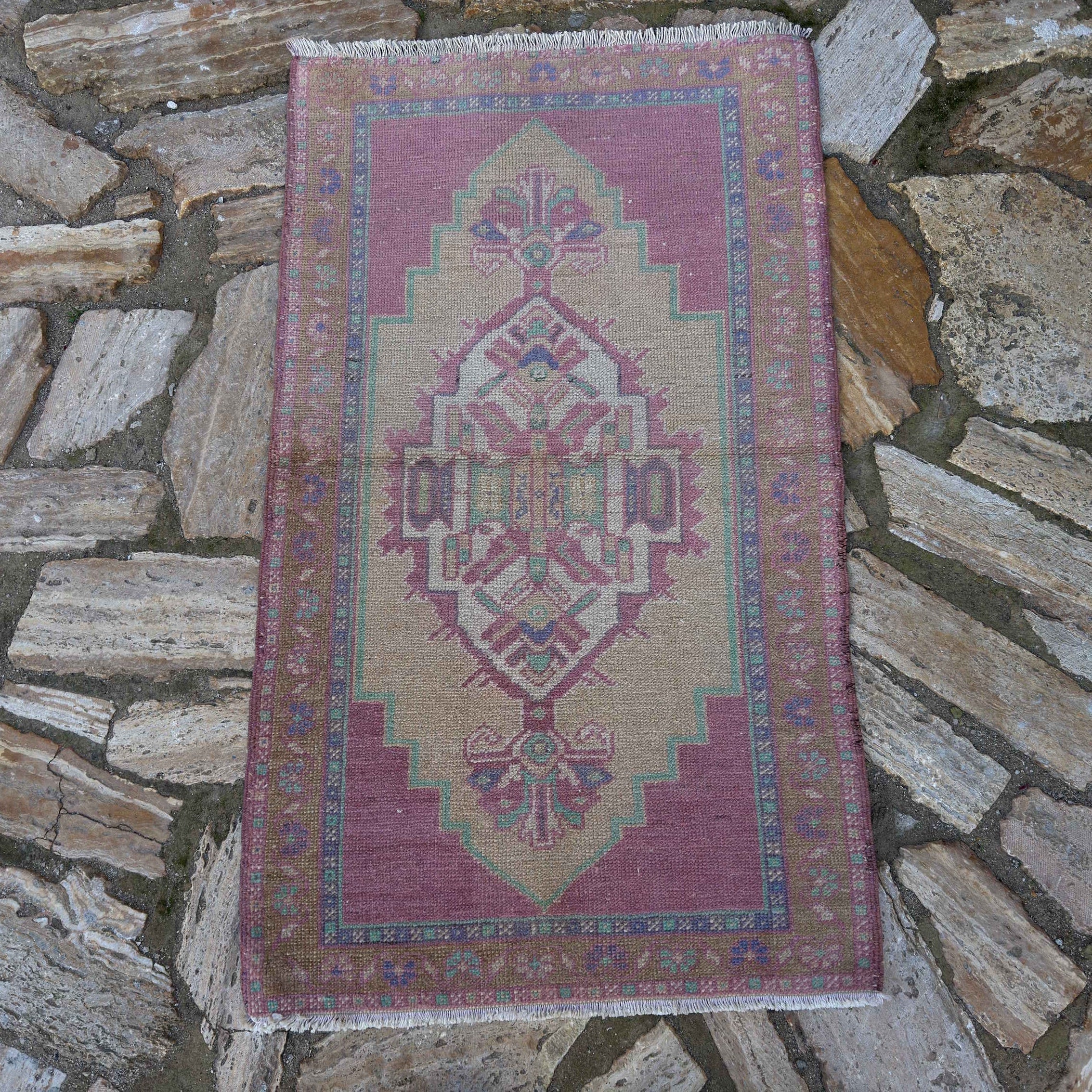 Pale Pink 2' x 4' vintage Turkish area rug in wool and cotton, shown on the floor.