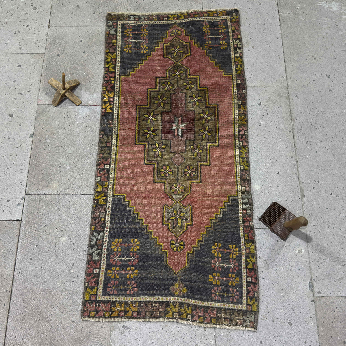 Pink 2' x 4' vintage Turkish area rug in wool and cotton, shown on the floor.