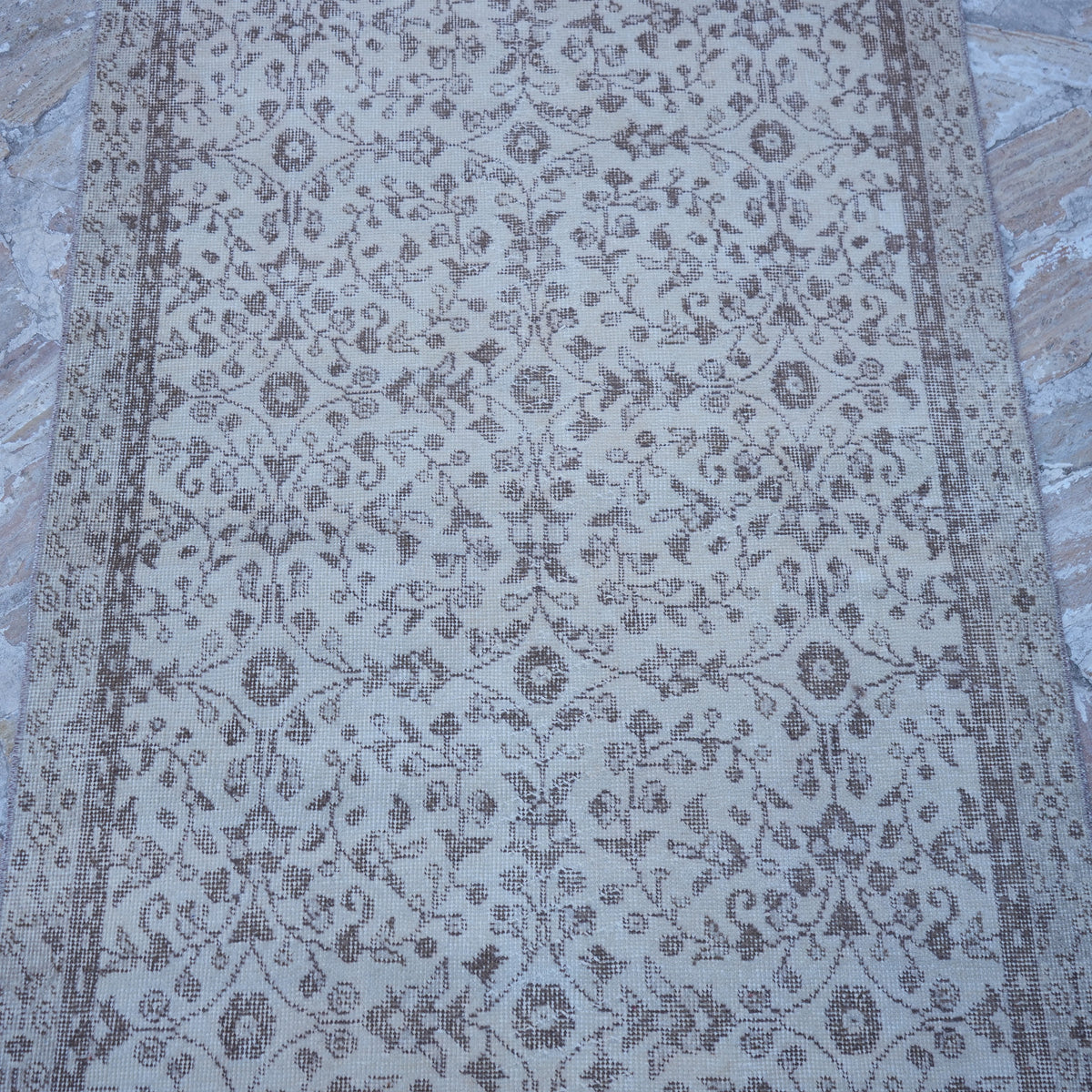 Close-up of the beige vintage Turkish area rug showing traditional details, hand-knotted weave, wool and cotton and low pile.