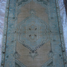 Close-up of the pale orange vintage Turkish area rug showing medallion details, hand-knotted weave, wool and cotton and low pile.
