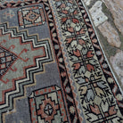 Close-up of the red vintage Turkish area rug showing traditional details, hand-knotted weave, wool and cotton and low pile.