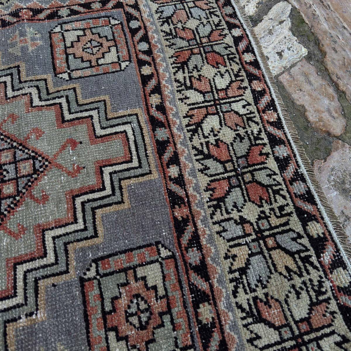 Close-up of the red vintage Turkish area rug showing traditional details, hand-knotted weave, wool and cotton and low pile.