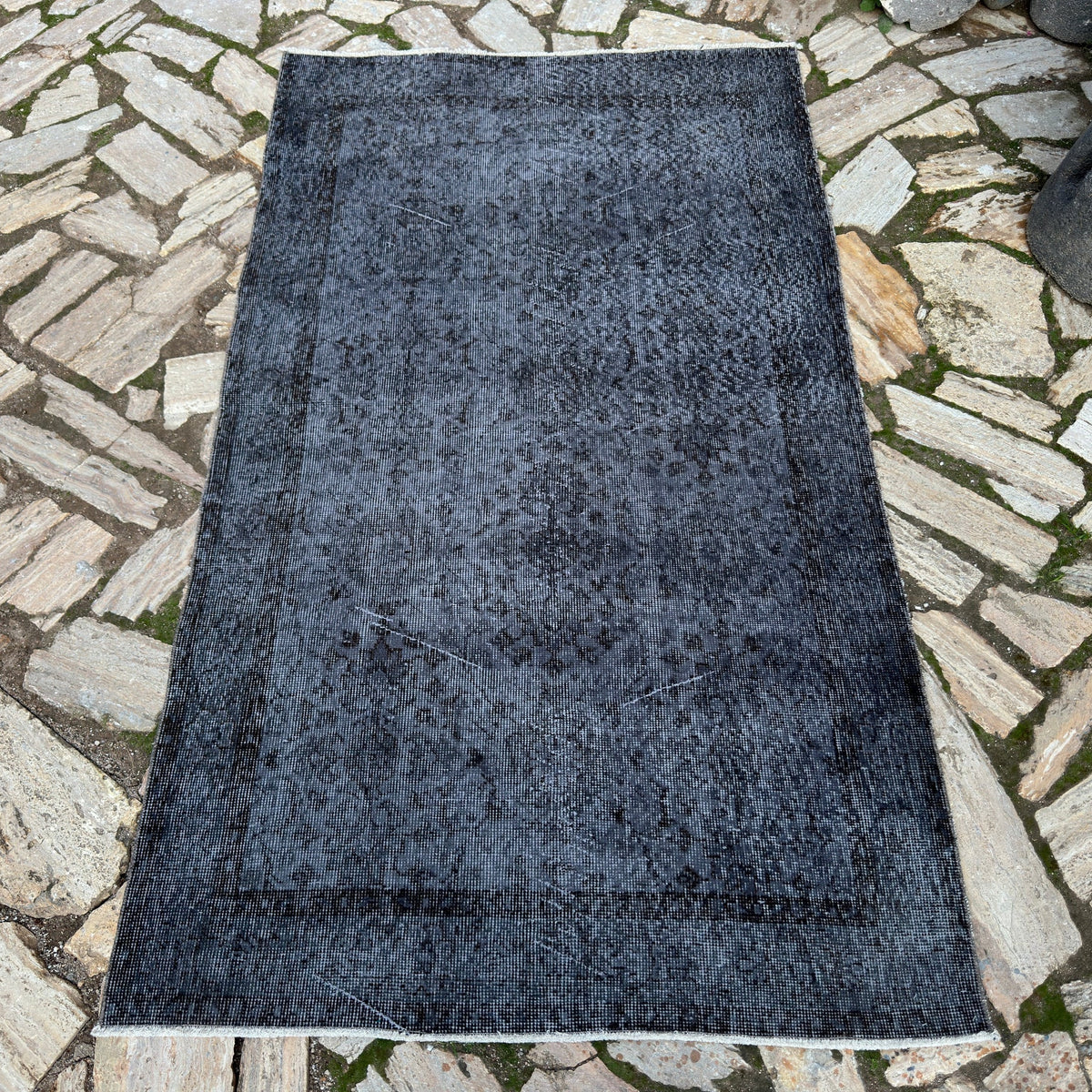 Black 4' x 6' vintage Turkish area rug in wool and cotton, shown on the floor.