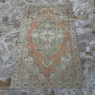 Close-up of the pale orange vintage Turkish area rug showing traditional details, hand-knotted weave, wool and cotton and low pile.