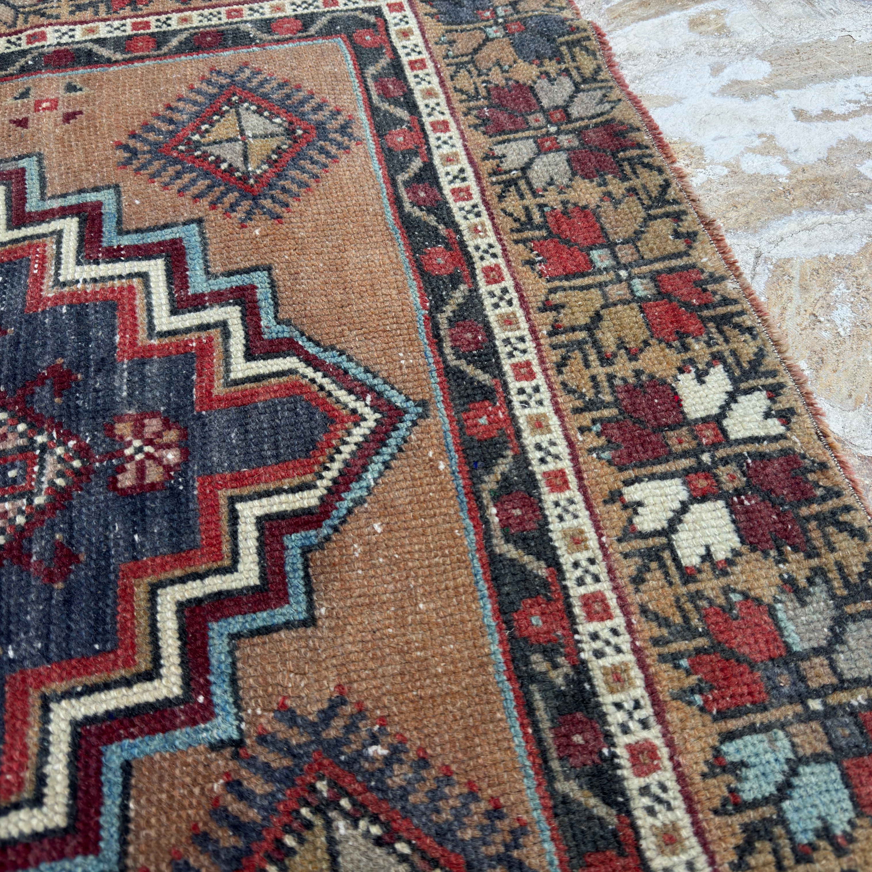 Close-up of the red vintage Turkish area rug showing traditional details, hand-knotted weave, wool and cotton and low pile.