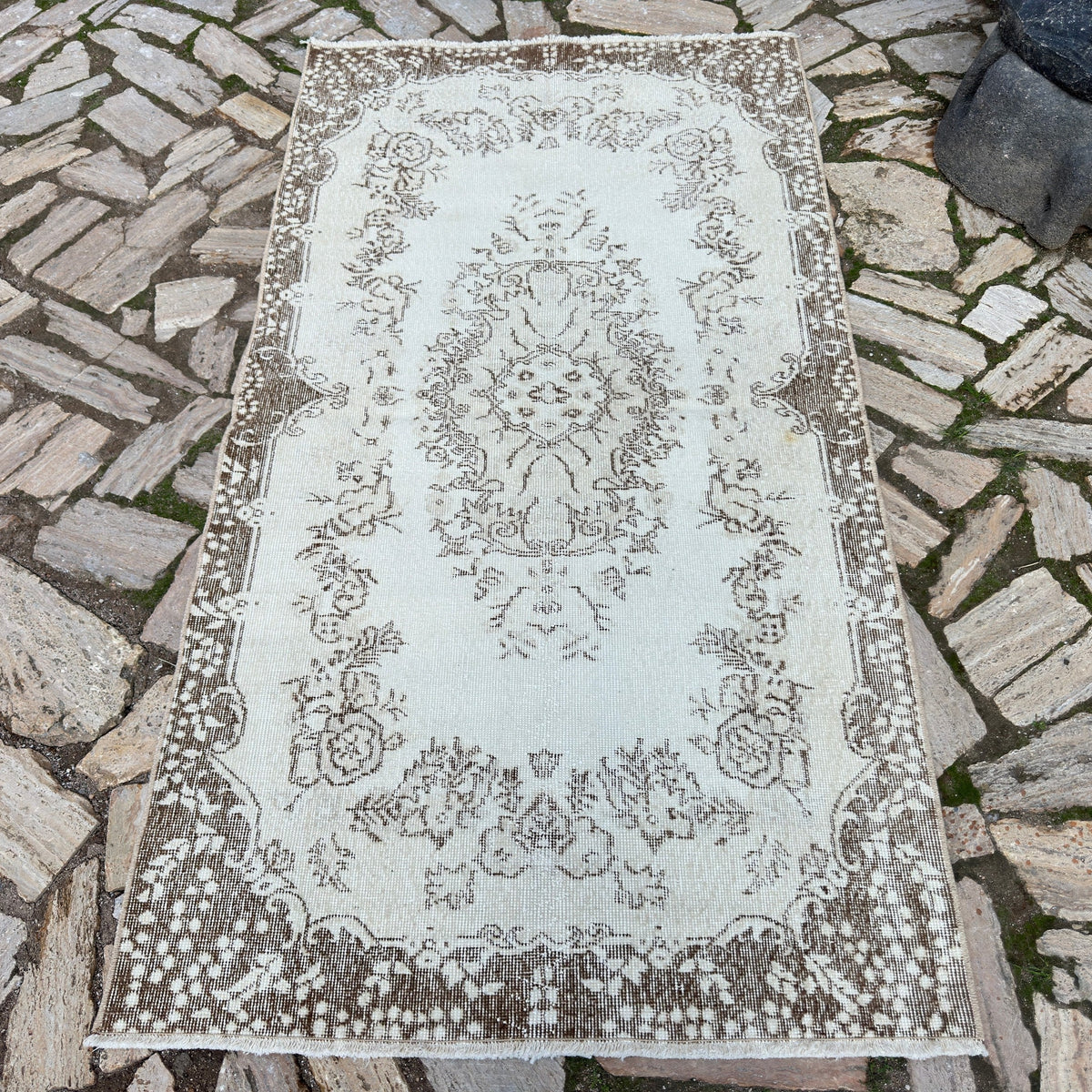 Beige 4' x 7' vintage Turkish area rug in wool and cotton, shown on the floor.