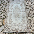 Beige 4' x 7' vintage Turkish area rug in wool and cotton, shown on the floor.