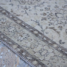 Beige 4' x 7' vintage Turkish area rug in wool and cotton, shown on the floor.