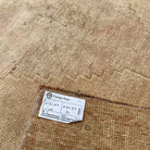 Close-up of the brown vintage Turkish area rug showing neutral details, hand-knotted weave, wool and cotton and low pile.