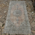 Close-up of the pale blue vintage Turkish area rug showing neutral details, hand-knotted weave, wool and cotton and low pile.