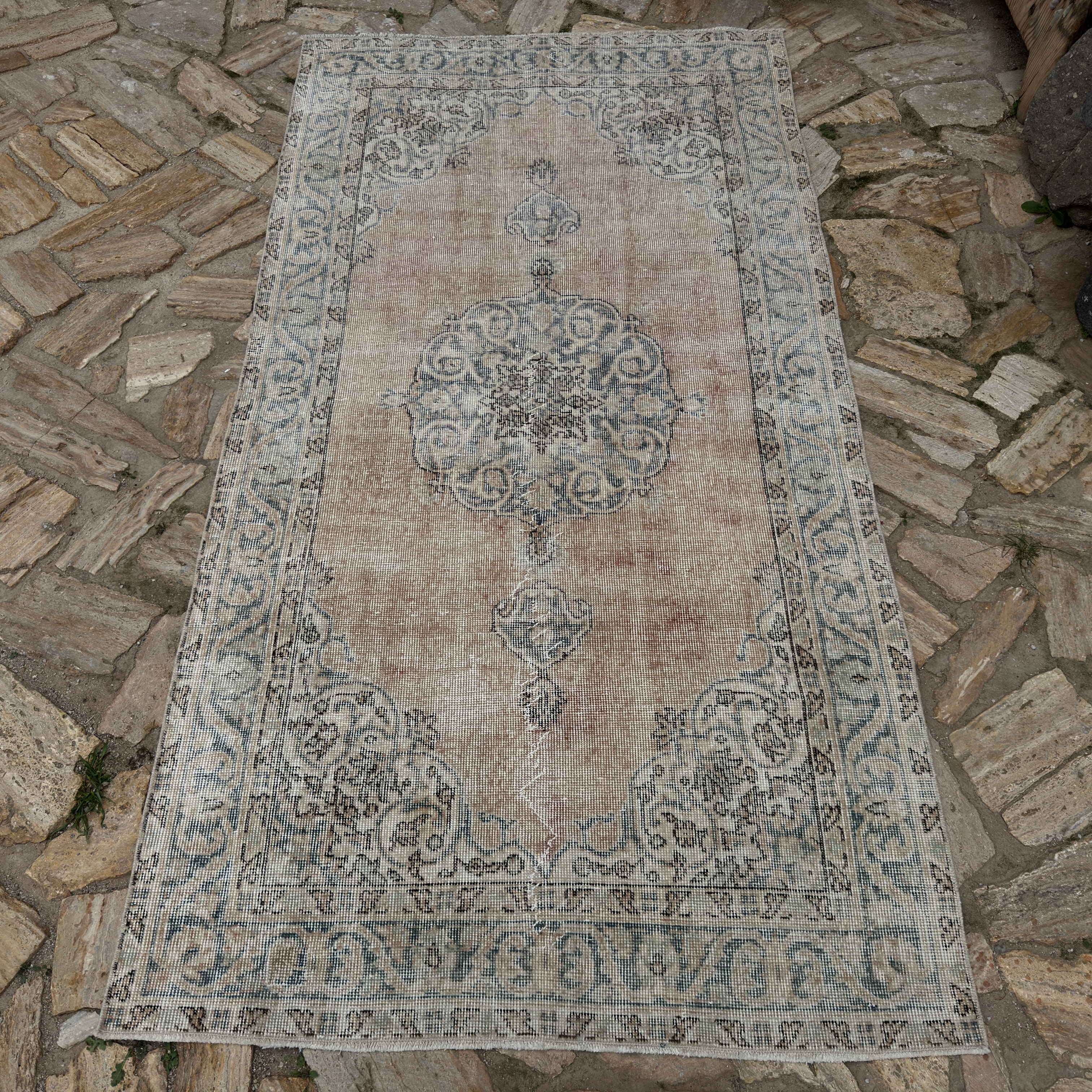 Close-up of the pale blue vintage Turkish area rug showing neutral details, hand-knotted weave, wool and cotton and low pile.