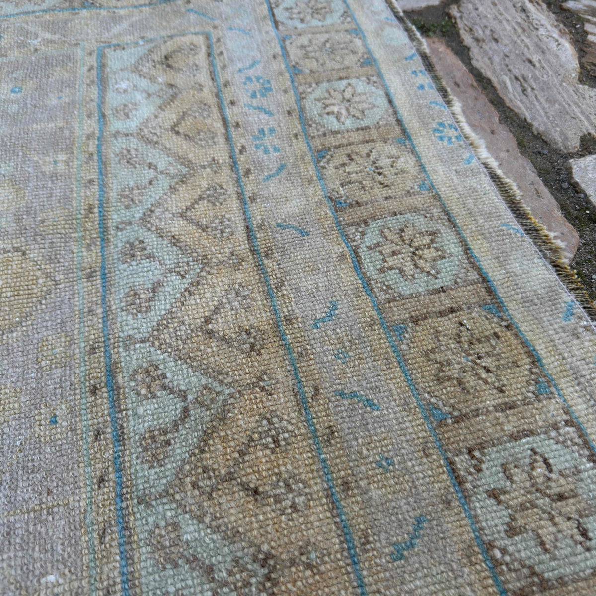 Close-up of the pale yellow vintage Turkish area rug showing neutral details, hand-knotted weave, wool and cotton and low pile.