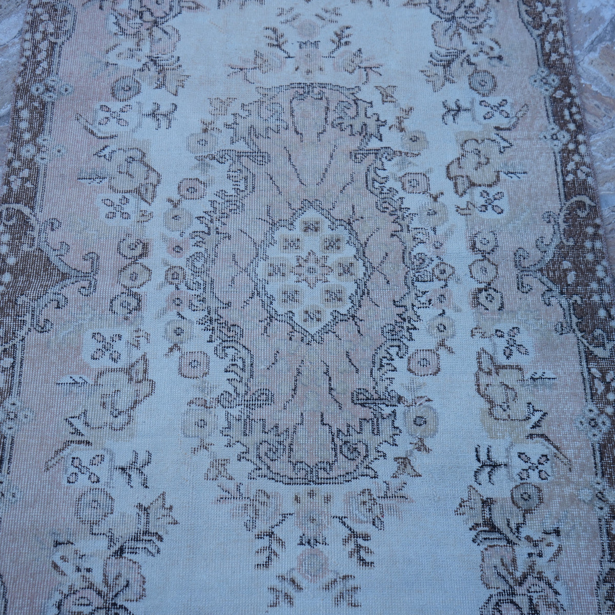 Close-up of the pink vintage Turkish area rug showing traditional details, hand-knotted weave, wool and cotton and low pile.