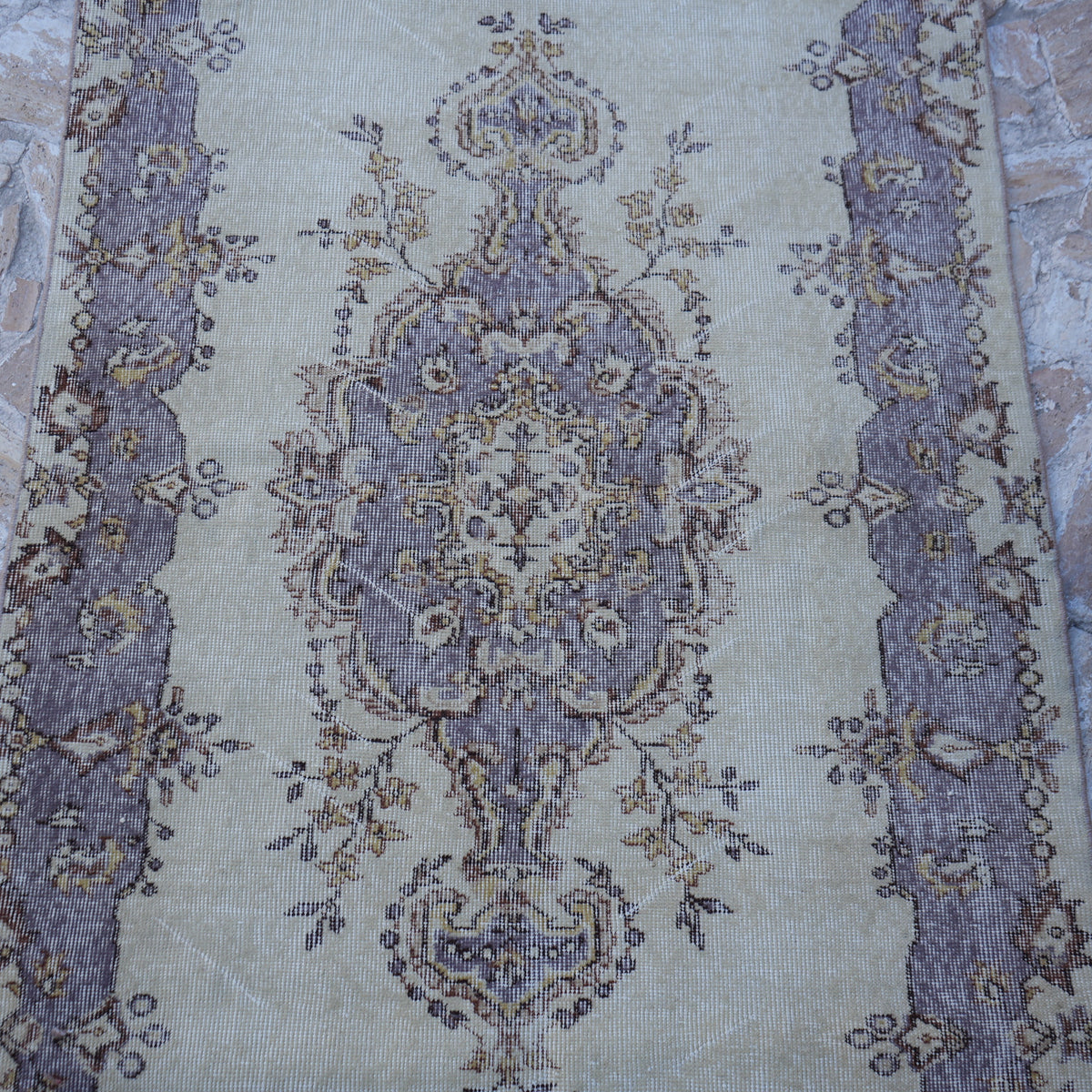 Close-up of the purple vintage Turkish area rug showing traditional details, hand-knotted weave, wool and cotton and low pile.