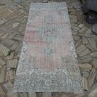Pale Red 4' x 8' vintage Turkish area rug in wool and cotton, shown on the floor.