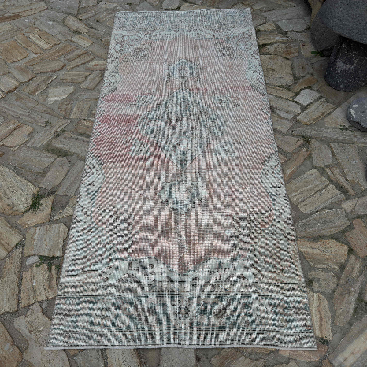 Pale Red 4' x 8' vintage Turkish area rug in wool and cotton, shown on the floor.