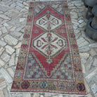 Red 4' x 9' vintage Turkish area rug in wool and cotton, shown on the floor.