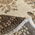 Close-up of the brown vintage Turkish area rug showing medallion details, hand-knotted weave, wool and cotton and low pile.