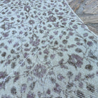 Close-up of the beige vintage Turkish area rug showing floral and neutral details, hand-knotted weave, wool and cotton and low pile.