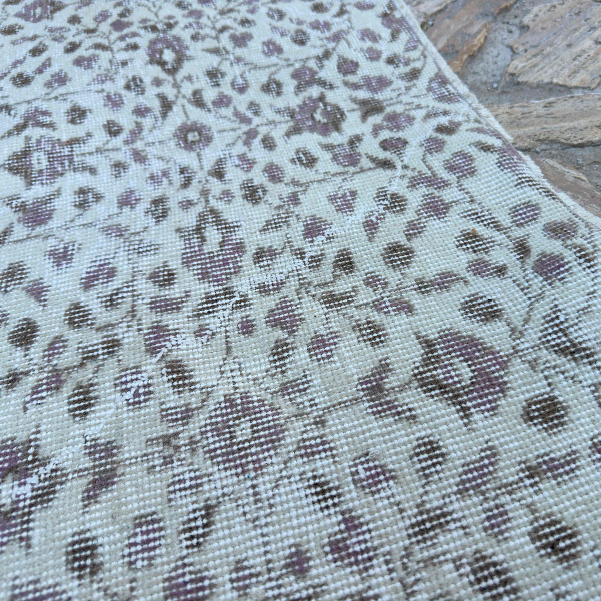 Close-up of the beige vintage Turkish area rug showing floral and neutral details, hand-knotted weave, wool and cotton and low pile.