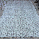 Beige 7' x 10' vintage Turkish area rug in wool and cotton, shown on the floor.