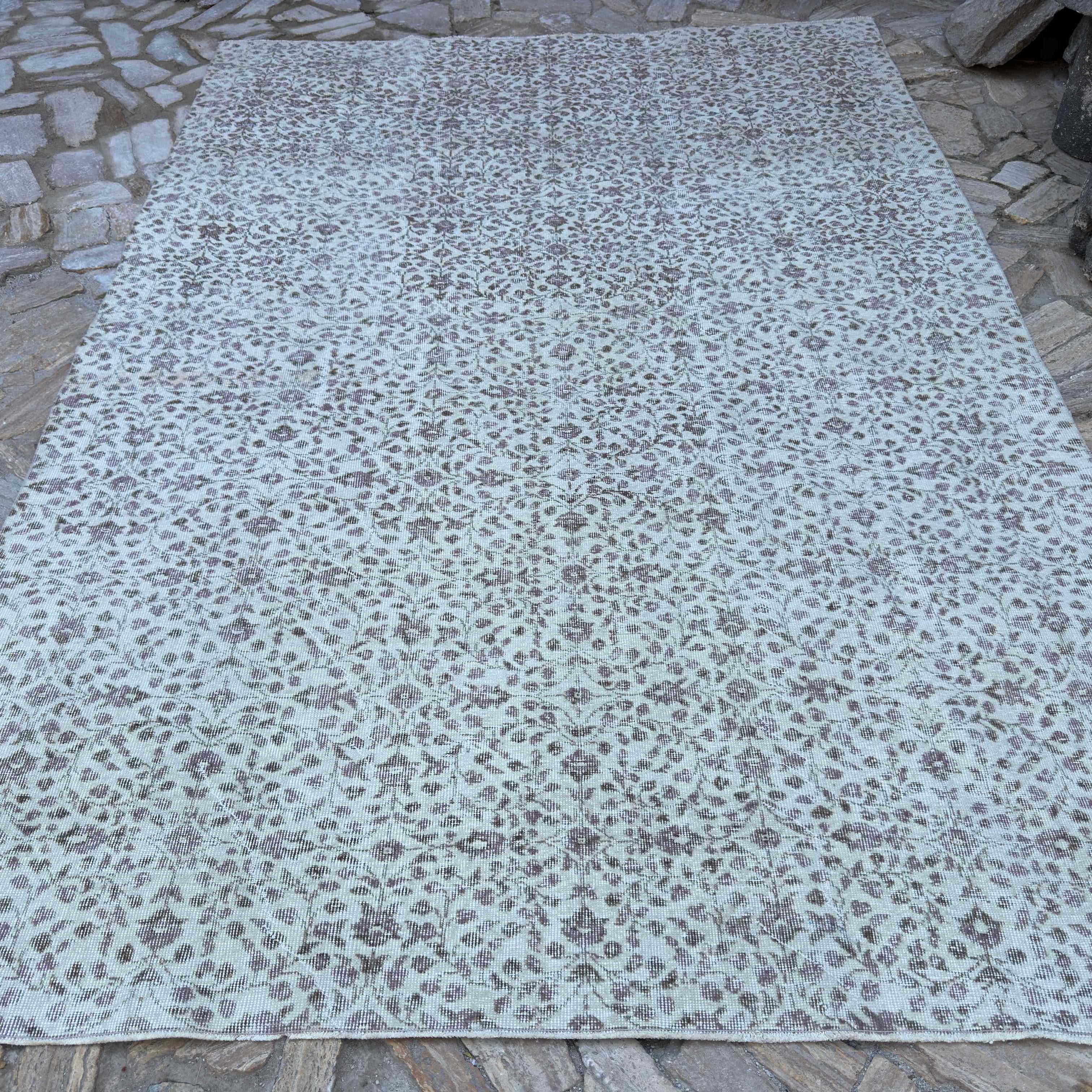 Beige 7' x 10' vintage Turkish area rug in wool and cotton, shown on the floor.