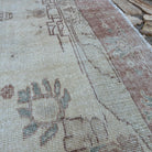 Close-up of the pale red vintage Turkish area rug showing medallion details, hand-knotted weave, wool and cotton and low pile.