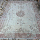 Pale Red 7' x 9' vintage Turkish area rug in wool and cotton, shown on the floor.