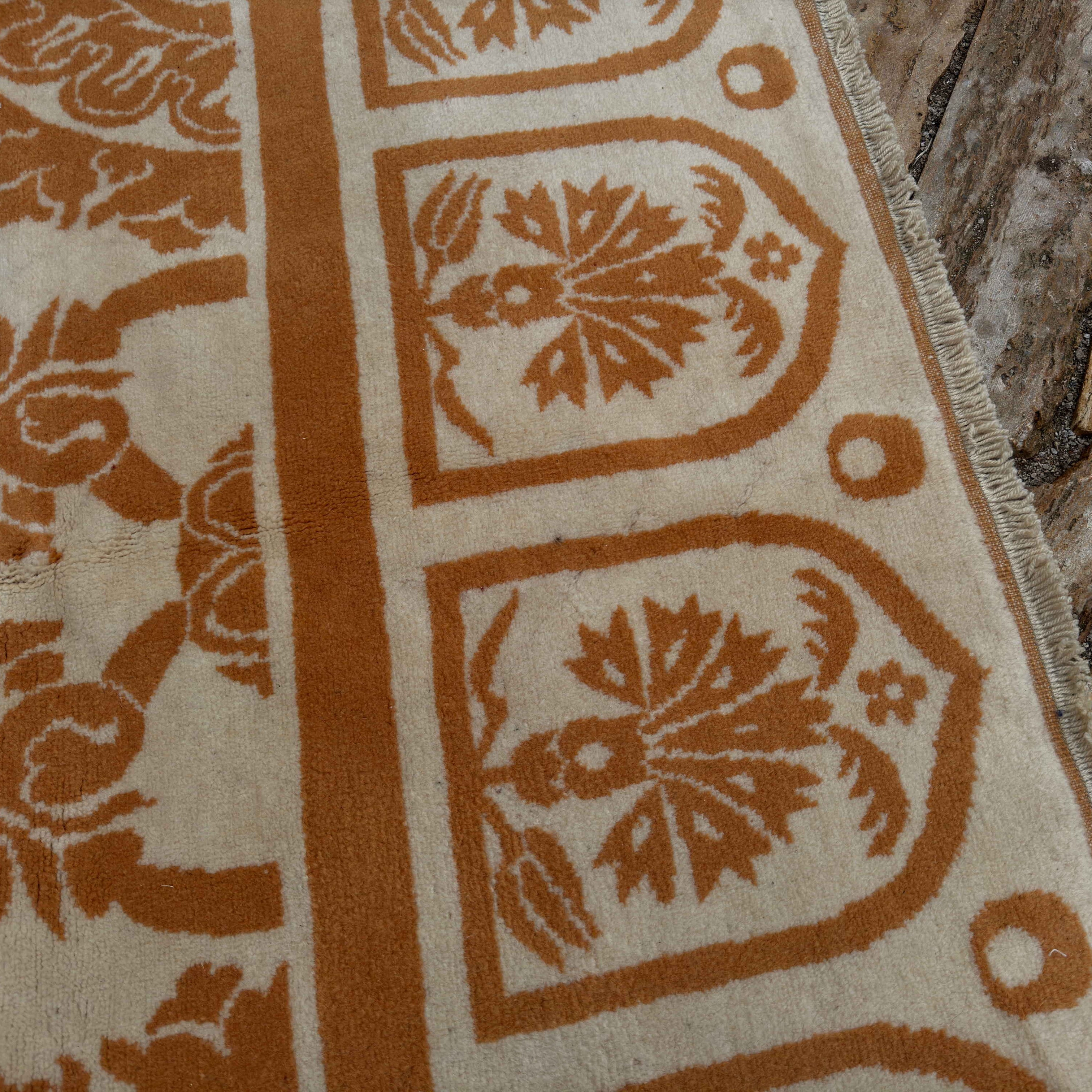 Close-up of the pale orange vintage Turkish art deco rug showing traditional and medallion details, hand-knotted weave, wool and cotton and low pile.