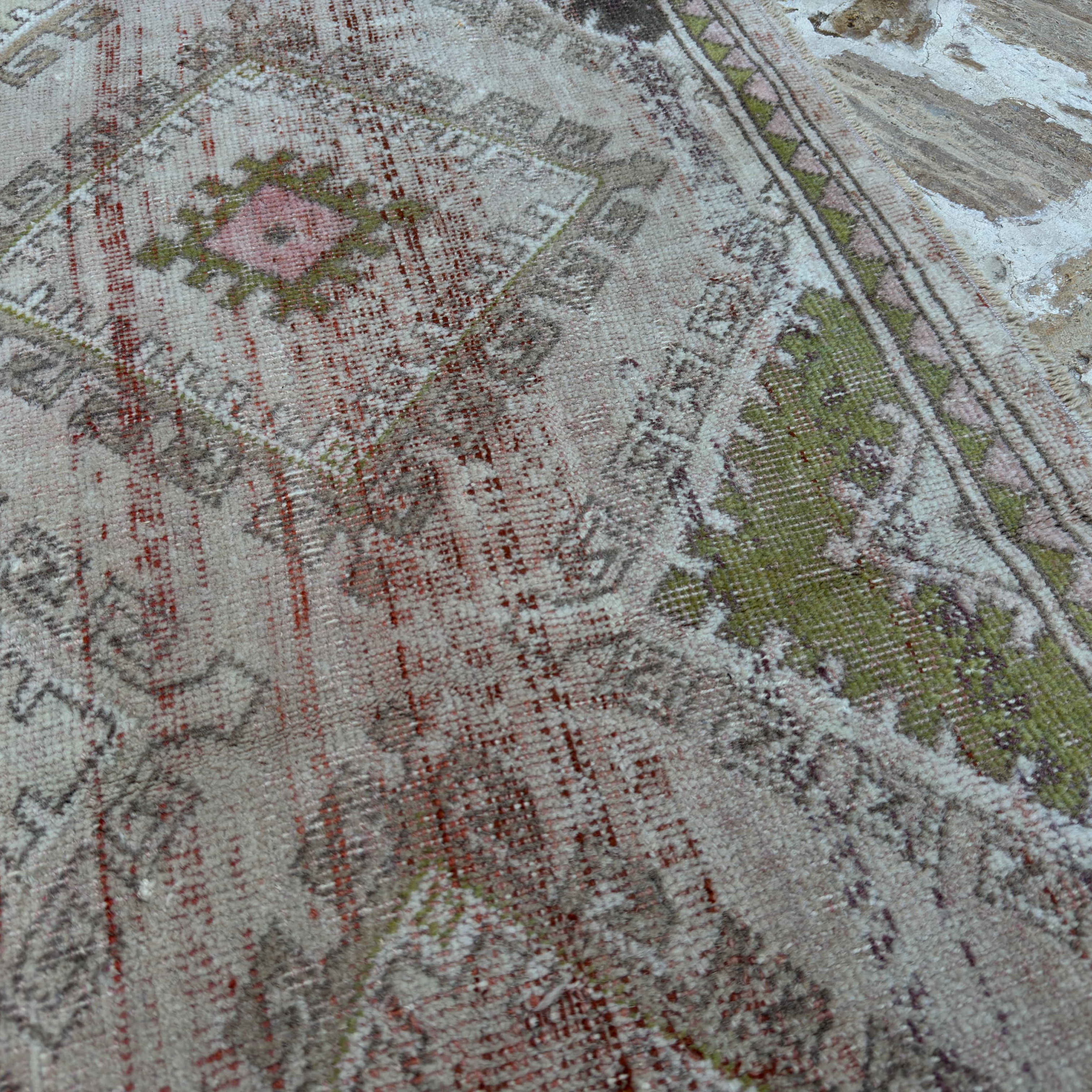 Close-up of the beige vintage Turkish bohemian rug showing traditional and neutral details, hand-knotted weave, wool and cotton and low pile.