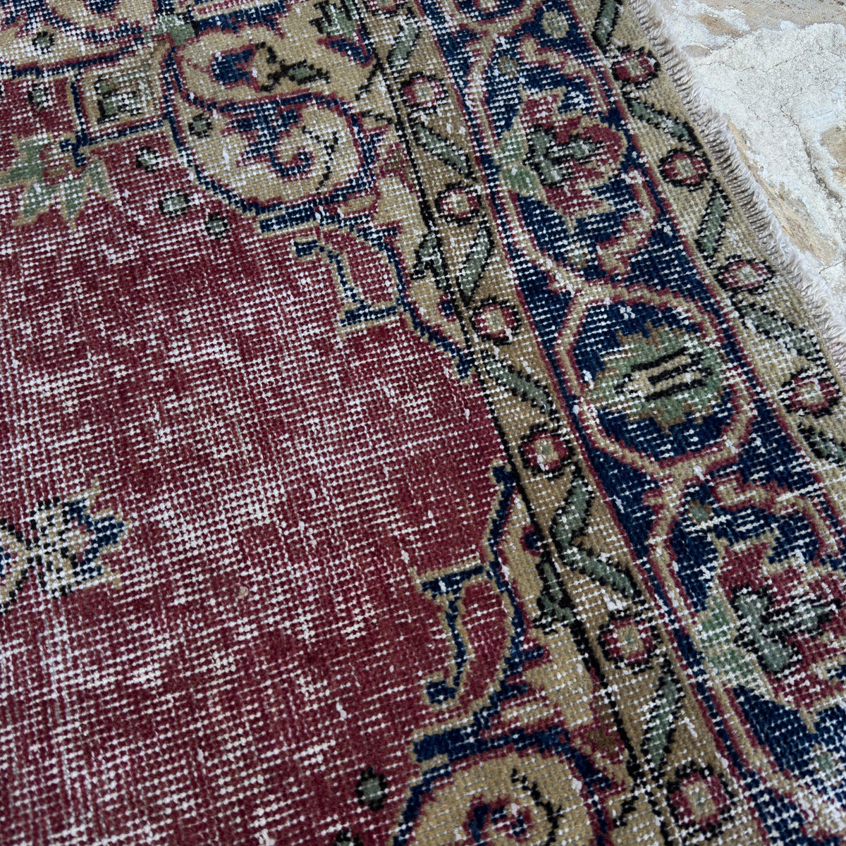 Close-up of the red vintage Turkish decorative rug showing medallion details, hand-knotted weave, wool and cotton and low pile.