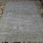 Pale Gray 7' x 9' vintage Turkish distressed carpet in wool and cotton, shown on the floor.