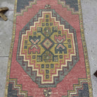 1970s red vintage Turkish distressed rug with traditional design, hand-knotted weave and low pile.