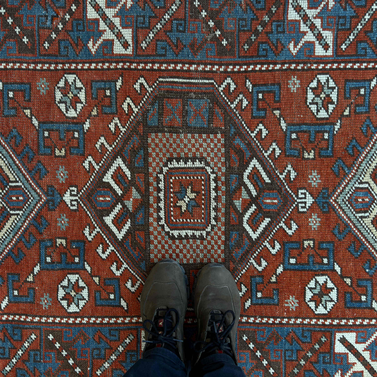 1970s red vintage Turkish distressed rug with traditional design, hand-knotted weave and low pile.