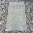 Beige 3' x 5' vintage Turkish distressed rug in wool and cotton, shown on the floor.