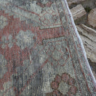 Close-up of the red vintage Turkish distressed rug showing traditional details, hand-knotted weave, wool and cotton and low pile.