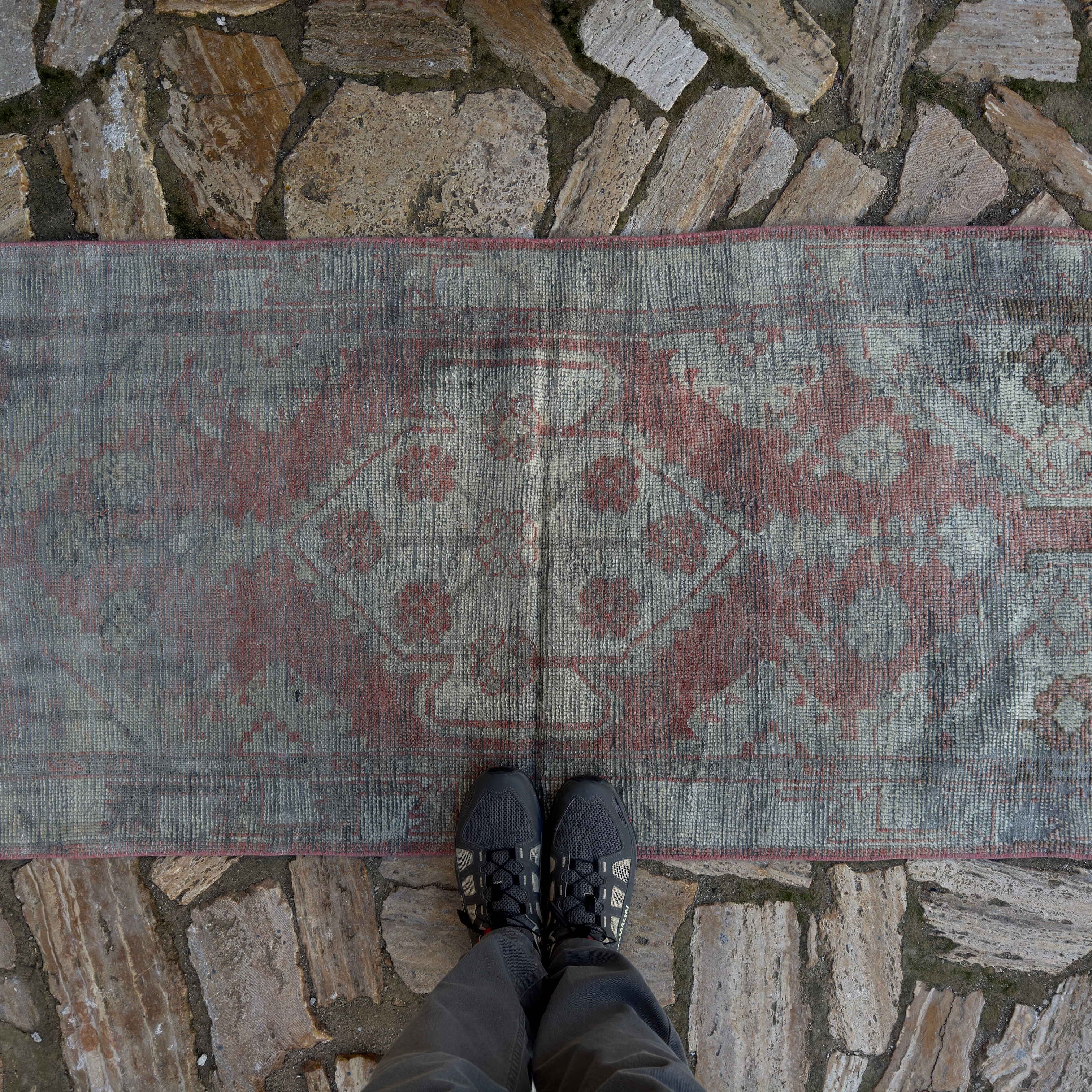1970s red vintage Turkish distressed rug with traditional design, hand-knotted weave and low pile.