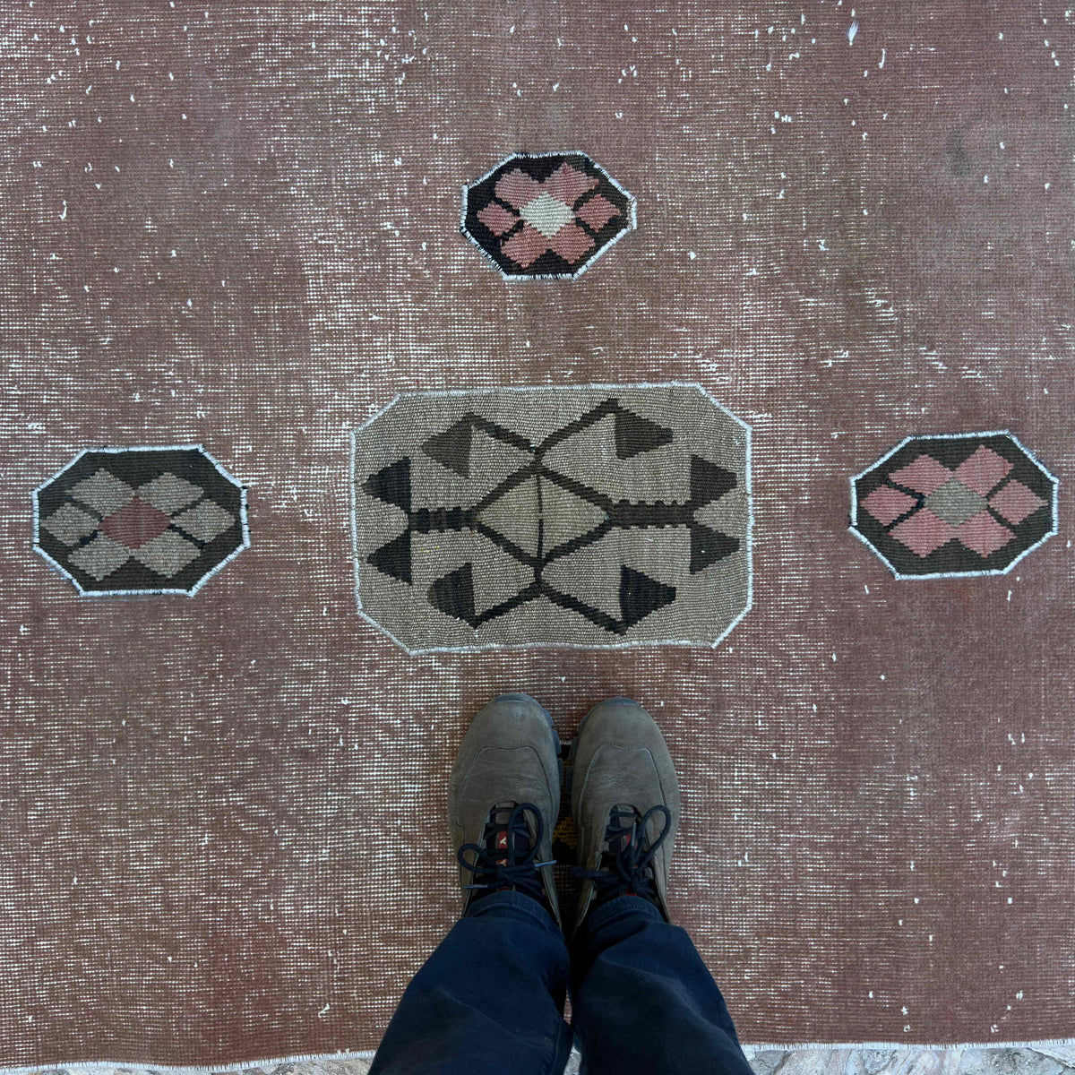 1970s pale red vintage Turkish distressed rug with patchwork design, hand-knotted weave and low pile.