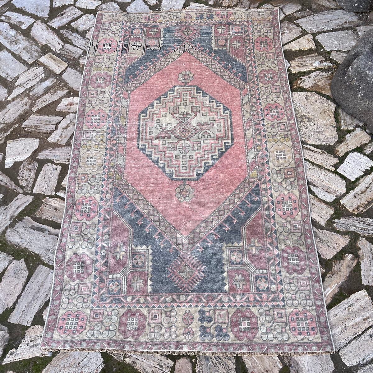 Pink 4' x 6' vintage Turkish distressed rug in wool and cotton, shown on the floor.