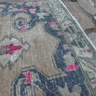 Close-up of the beige vintage Turkish distressed rug showing traditional details, hand-knotted weave, wool and cotton and low pile.