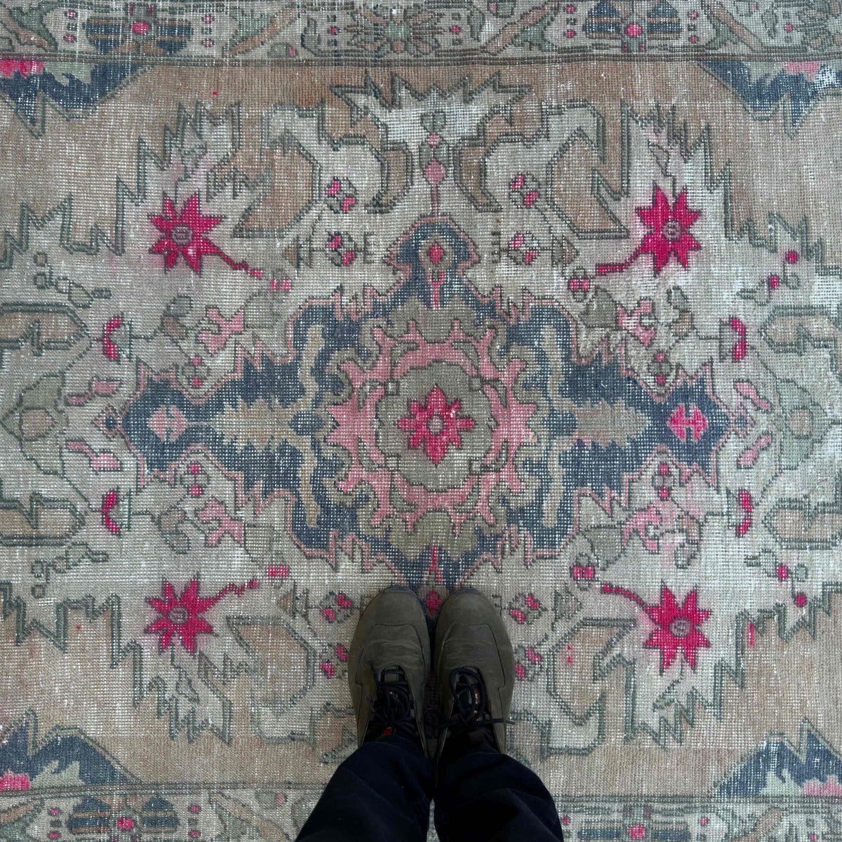 1970s beige vintage Turkish distressed rug with traditional design, hand-knotted weave and low pile.