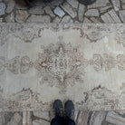 1970s beige vintage Turkish distressed rug with neutral design, hand-knotted weave and low pile.