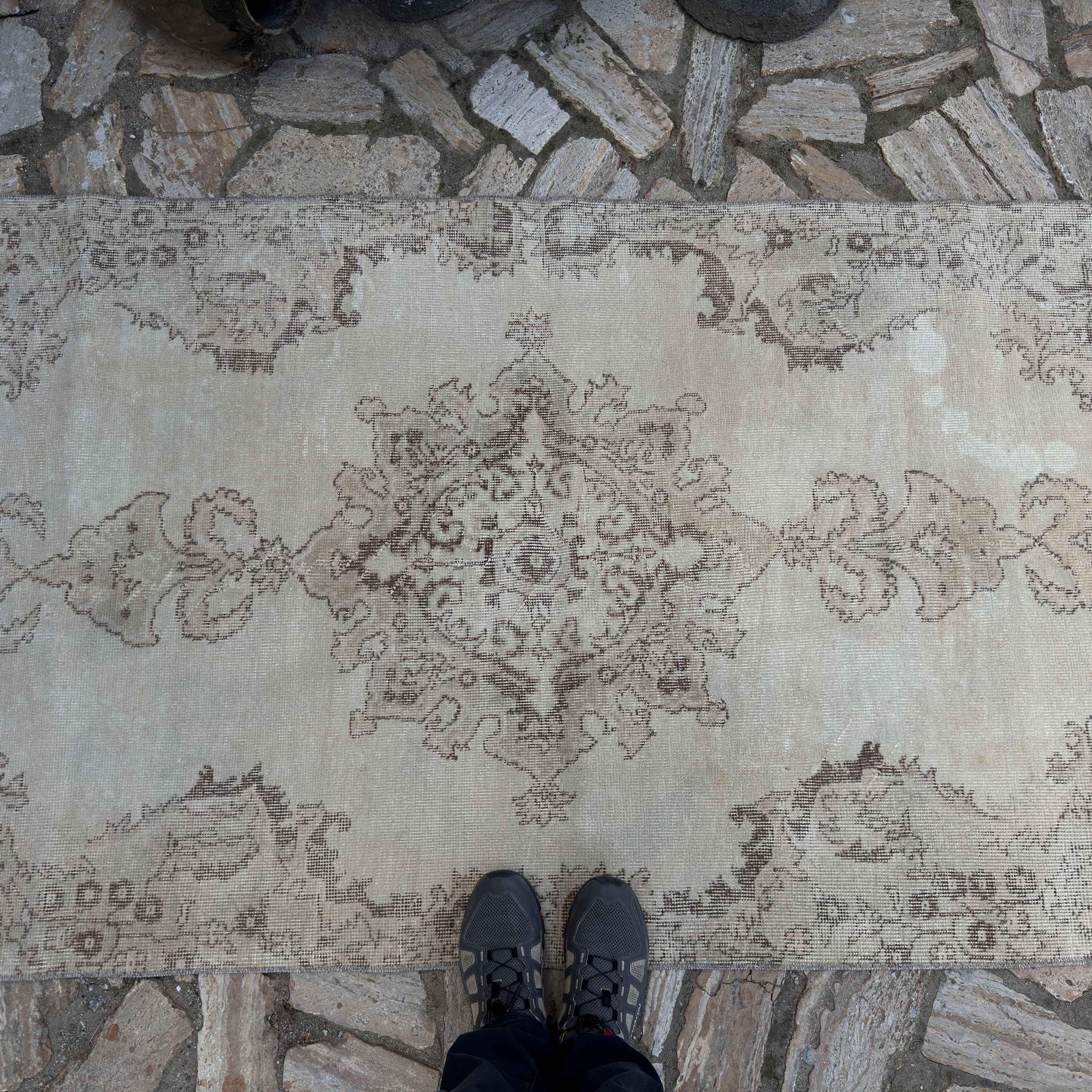 1970s beige vintage Turkish distressed rug with neutral design, hand-knotted weave and low pile.
