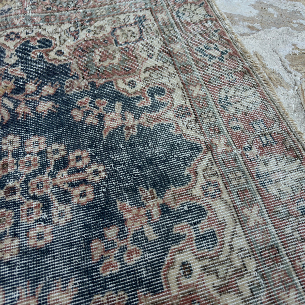 Close-up of the blue vintage Turkish distressed rug showing neutral details, hand-knotted weave, wool and cotton and low pile.